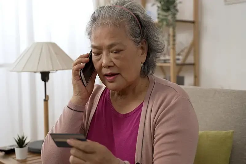 woman talking on the phone reading her cridit card