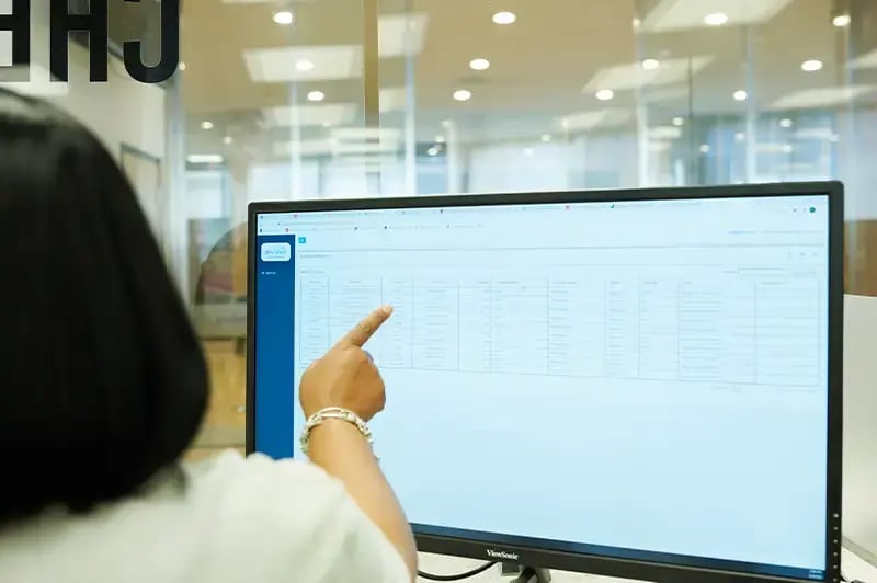 woman pointing at a report on a computer screen