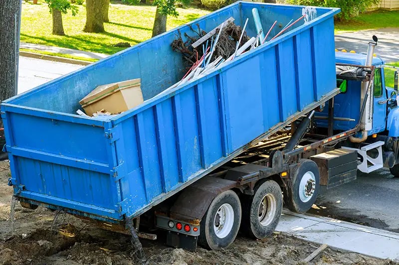 waste management truck picking up a dumpster
